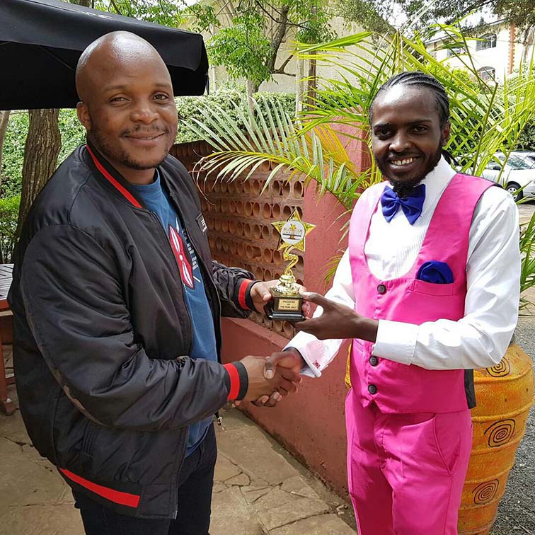 Amo La Moda Kenya C.E.O Dgohnie Hair Arts presenting Jalang'o with his award a day after the event